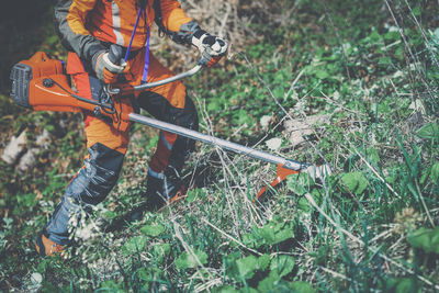 Man holding a brush cutter cut grass and brush. lumberjack at work . gardener working outdoor 