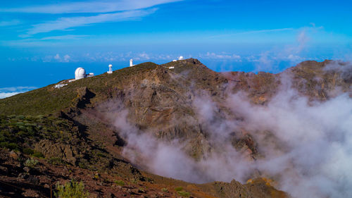 Smoke emitting from volcanic mountain against sky