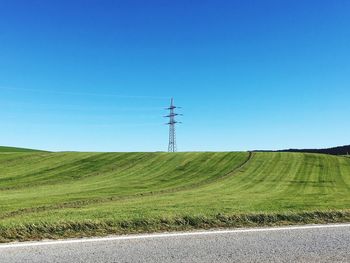 Electricity pylon on land against clear sky