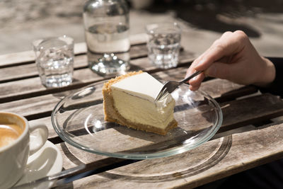 Human hand cutting pastry using fork