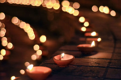 Close-up of illuminated diyas at night