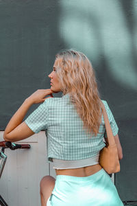 Midsection of woman standing against wall