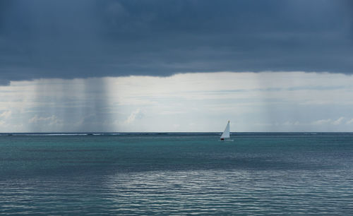 Sailboat sailing on sea against sky