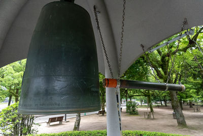 Low angle view of metallic structure against trees in park