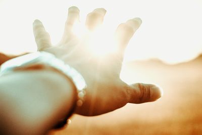 Close-up of hand against sky