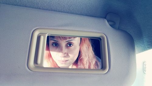 Reflection of woman on mirror in car