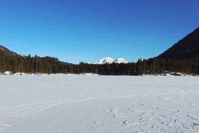 Scenic view of snowcapped mountains against clear blue sky