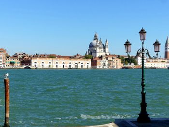 View of buildings in city against clear blue sky