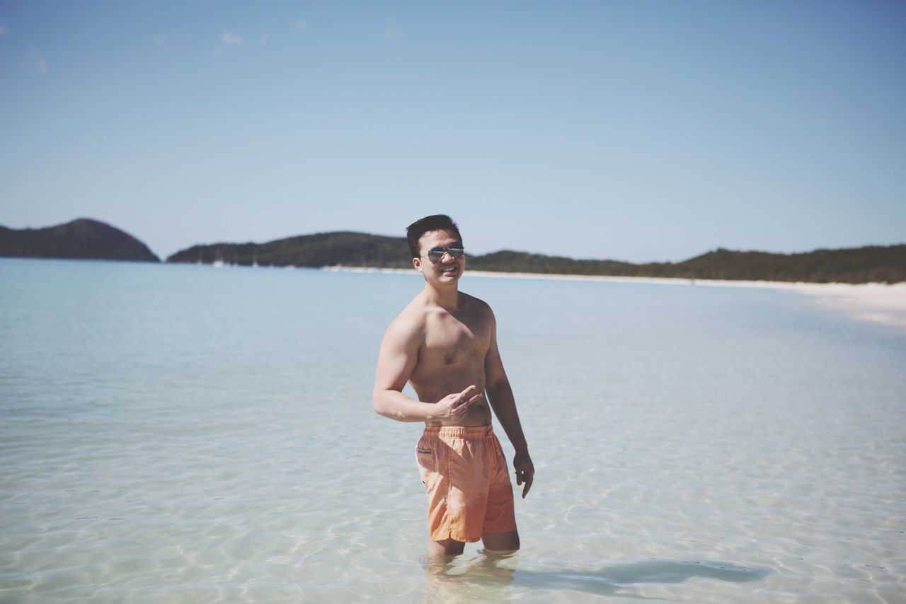 young adult, person, water, looking at camera, portrait, lifestyles, leisure activity, casual clothing, smiling, front view, young women, clear sky, standing, happiness, sea, beach, vacations