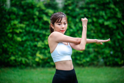 Portrait of young woman standing against blurred background