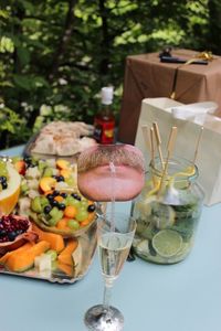 High angle view of fresh fruits and champagne on table in back yard