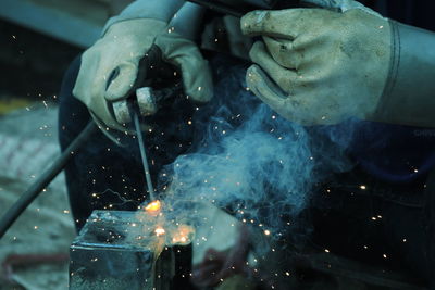 Midsection of man welding metal
