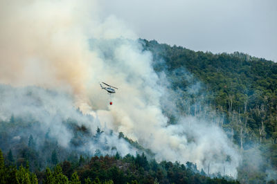 Helicopter flying over forest fire