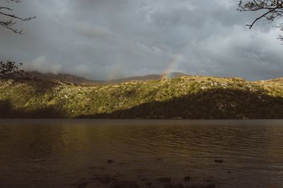 Scenic view of lake against storm clouds