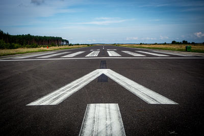 Diminishing perspective of road against blue sky