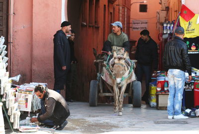 Men sitting on sidewalk in city