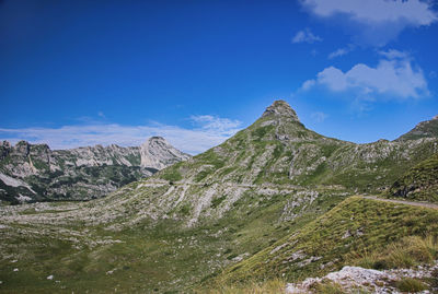 Scenic view of mountains against blue sky