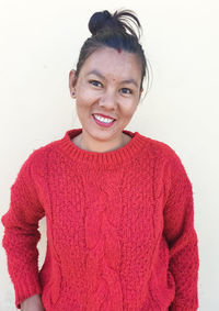 Portrait of smiling young woman against white background