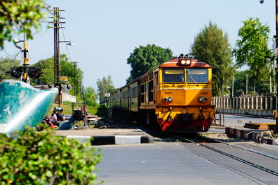 Train running through railroad crossing against sky