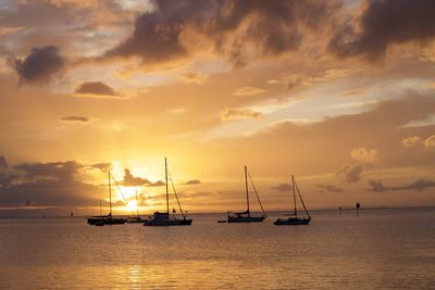 Sailboats on sea against sky during sunset