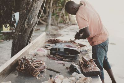 Man preparing food while standing outdoors