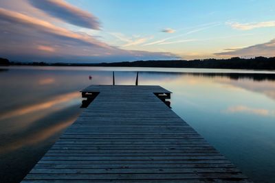 Pier on lake against sky during sunset