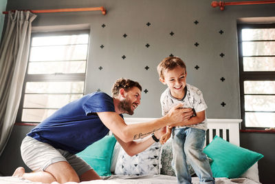 Father playing with son at home