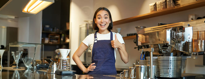 Portrait of young woman standing in cafe