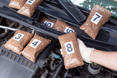 Cropped hand of person holding packet in car