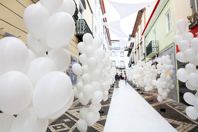 Low angle view of white balloons against sky