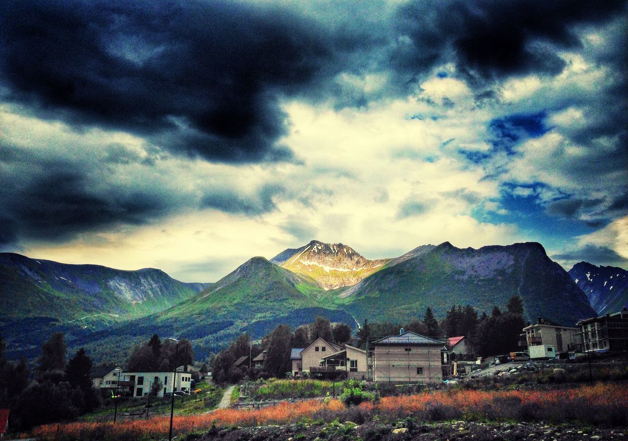 mountain, sky, cloud - sky, building exterior, mountain range, cloudy, architecture, built structure, house, landscape, scenics, beauty in nature, cloud, tranquil scene, weather, nature, tranquility, overcast, tree, village