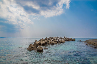 Rocks in sea against sky