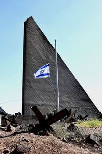 Low angle view of flag against clear blue sky