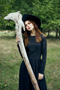 Portrait of young woman standing on field