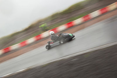 Blurred motion of person riding motorcycle on road