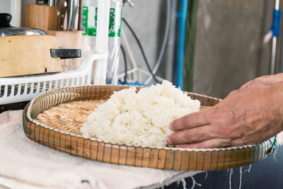 Place the steamed glutinous rice on a bamboo tray to allow heat to spread.