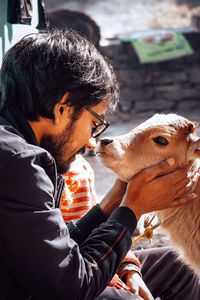 Close-up of man with cow calf outdoors