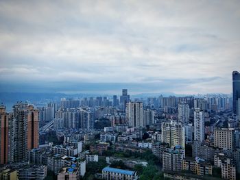 View of cityscape against cloudy sky
