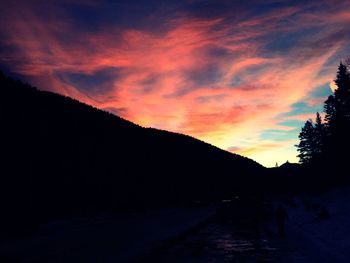 Scenic view of mountains against cloudy sky at sunset