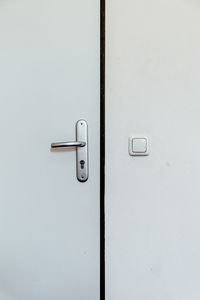Full frame shot of closed white door by wall