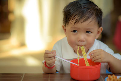 Portrait of cute boy drinking glass on table