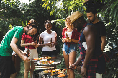 Young couple standing on barbecue grill