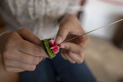 Close-up of woman holding flower in needle