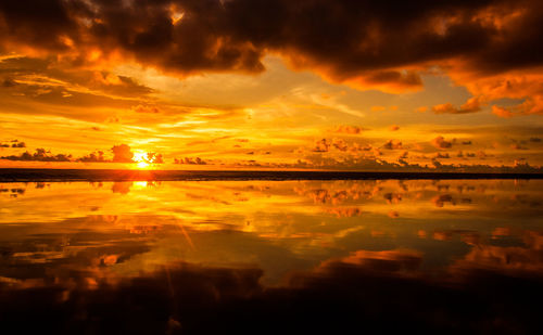 Scenic view of dramatic sky over sea during sunset