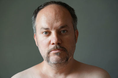 Portrait of shirtless man against gray background