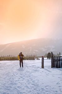 Man standing on snow covered mountain against clear sky