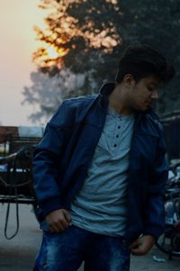 Young man posing on street at sunset during winter