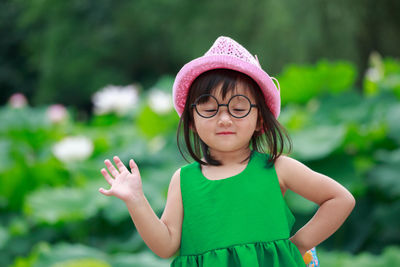 Close-up of girl standing against plants 