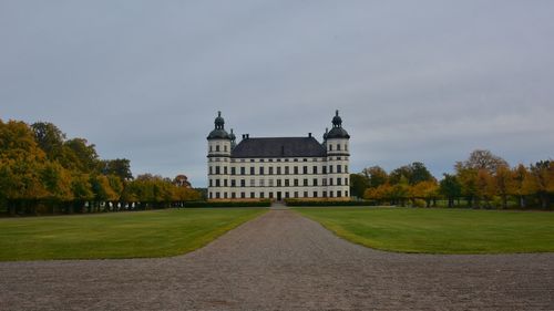 Lawn by building against sky