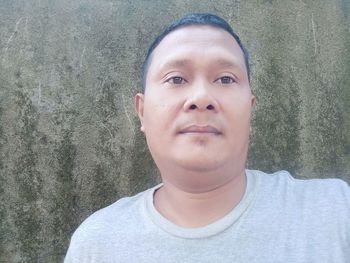 Close-up portrait of young man against wall